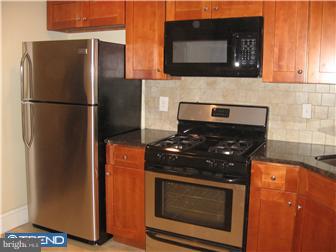 271 Copley Road Upper Darby, PA 19082 - Photo 2 of 12 a kitchen with stainless steel appliances granite countertop a stove a refrigerator and a microwave
