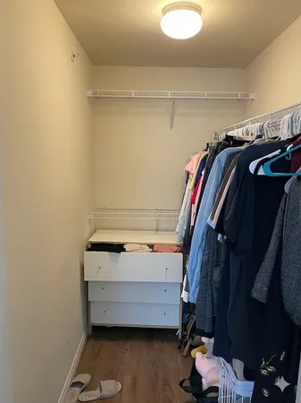 a view of walk in closet with clothes and shoes