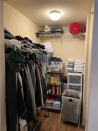 a view of walk in closet with clothes and shoes