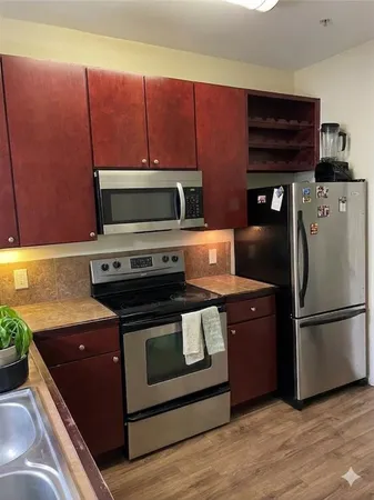 a kitchen with wooden cabinets and stainless steel appliances