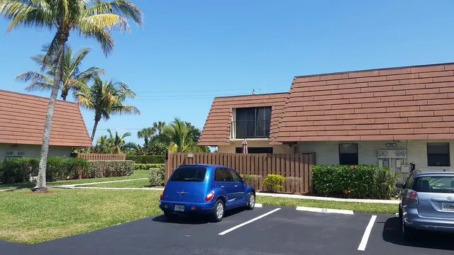 a car parked in front of a house with a yard