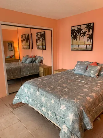 a bedroom with a bed and a painting on the wall