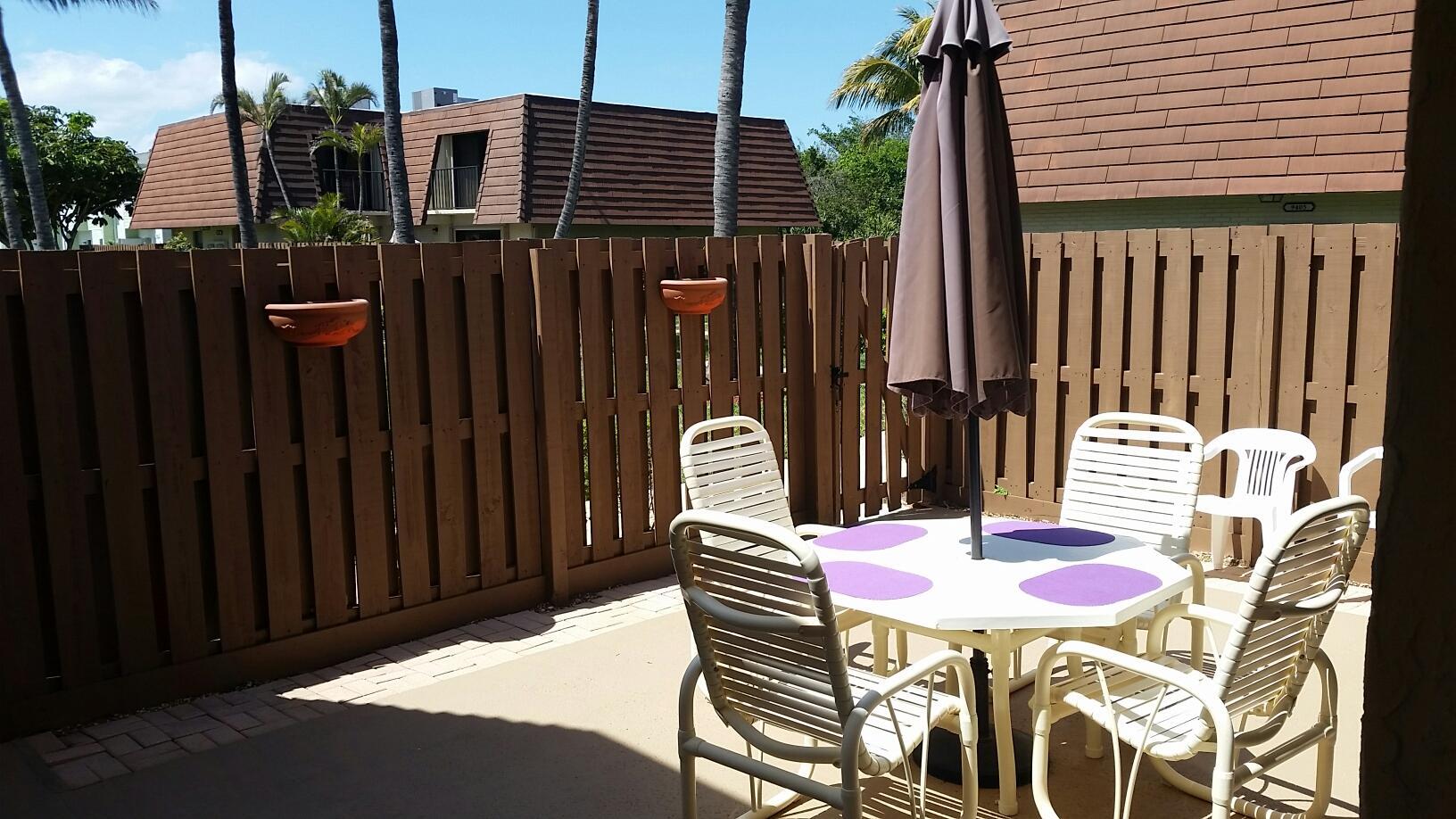 9403 South Ocean Drive, Unit 3D Jensen Beach, FL 34957 - Photo 2 of 15 a backyard of a house with table and chairs