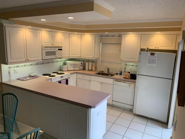 a kitchen with a sink a refrigerator and cabinets