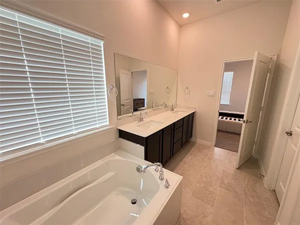 a bathroom with a tub sink and a mirror