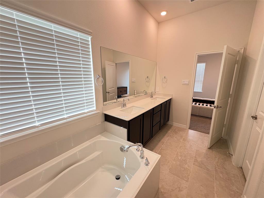3823 Tack Aubrey, TX 76227 - Photo 15 of 27 a bathroom with a tub sink and a mirror