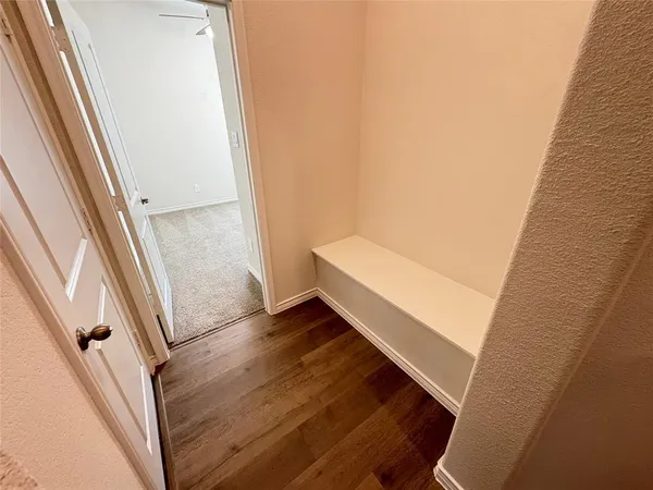 an empty room with a window and a fan