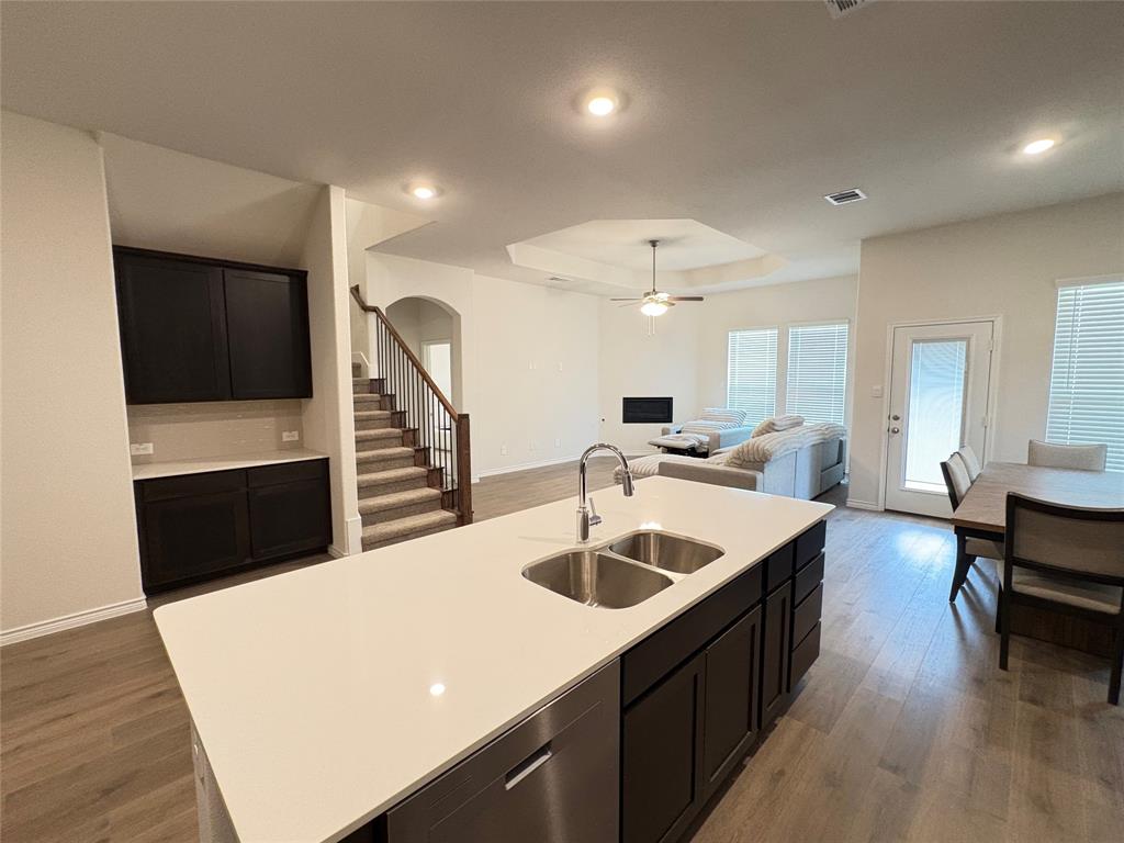 3823 Tack Aubrey, TX 76227 - Photo 8 of 27 a large white kitchen with a sink a refrigerator and chairs