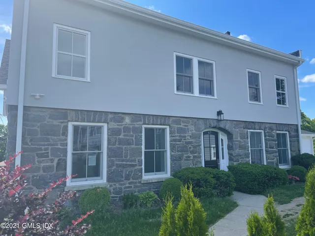 a large brick building with a bench in front of it