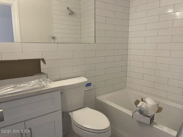 a bathroom with a granite countertop toilet a sink and bathtub