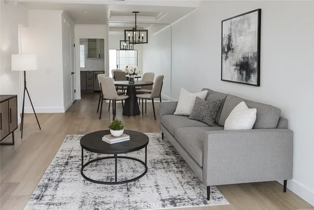a living room with furniture a dining table and a chandelier