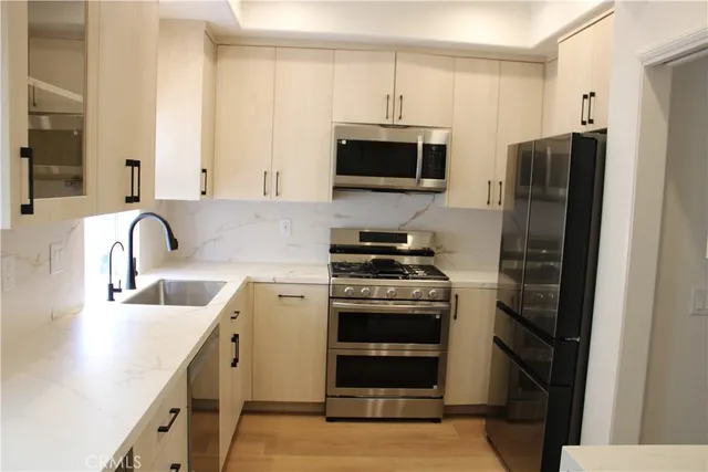 a kitchen with stainless steel appliances a stove a sink and a microwave