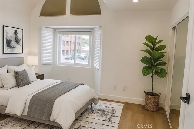 a bedroom with a bed a couch and potted plant