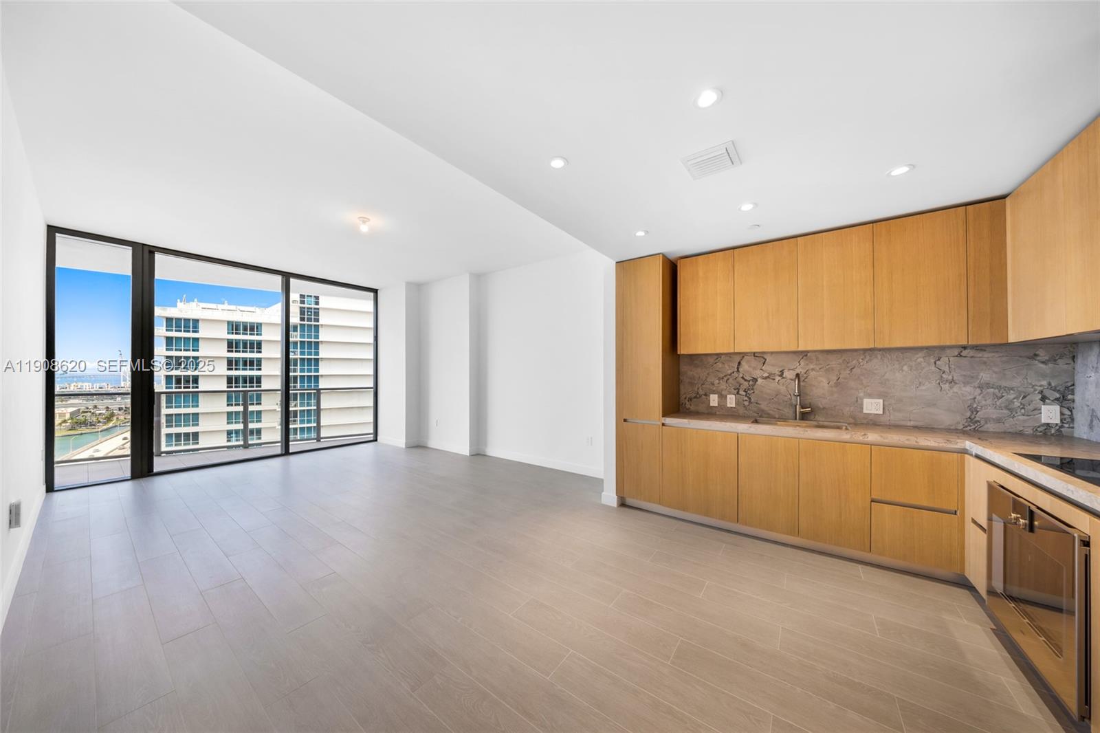 500 Alton Road, Unit 1904 Miami Beach, FL 33139 - Photo 14 of 28 a view of an empty room with a window and wooden floor