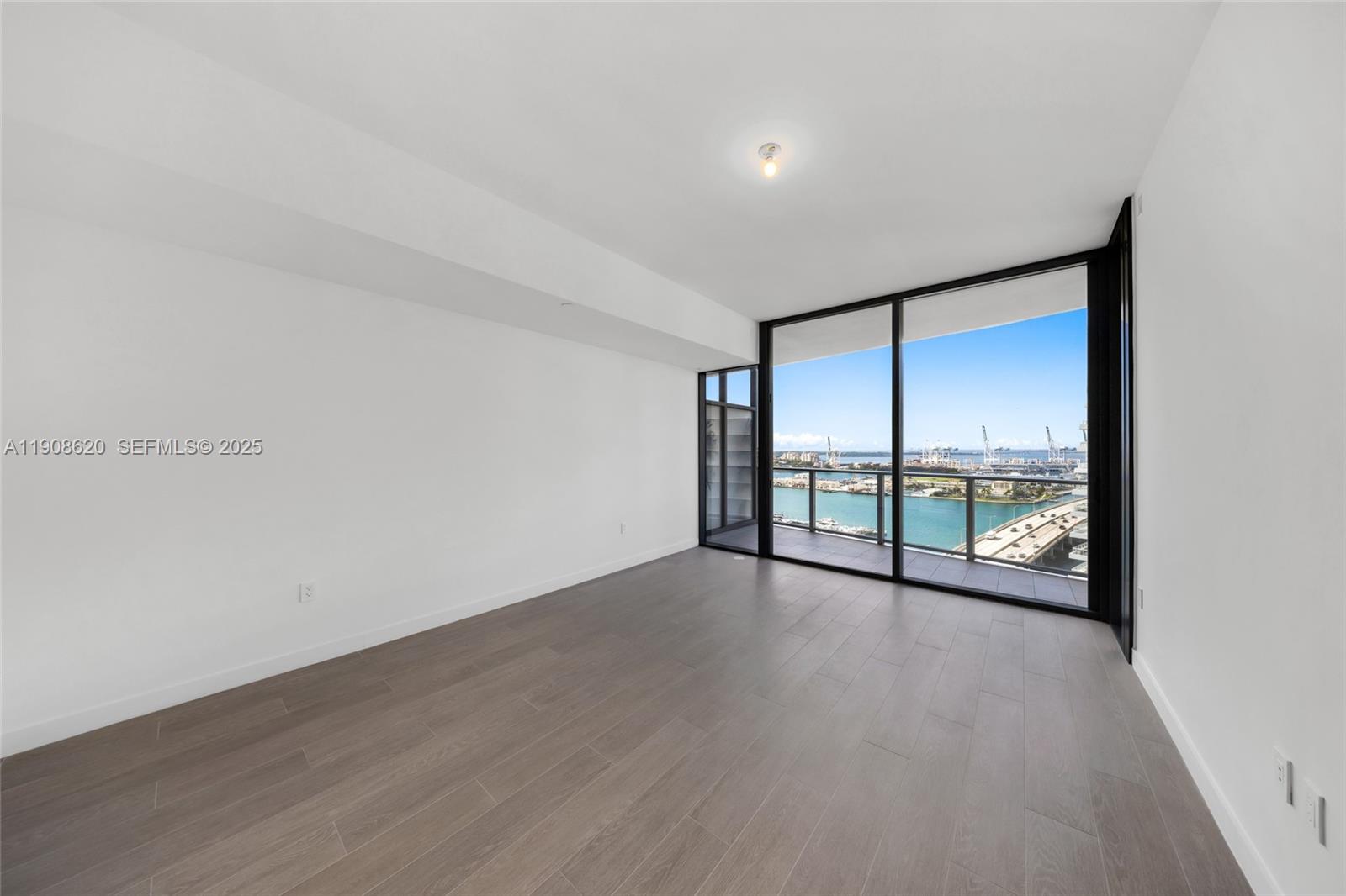 500 Alton Road, Unit 1904 Miami Beach, FL 33139 - Photo 21 of 28 a view of an empty room with wooden floor and a window