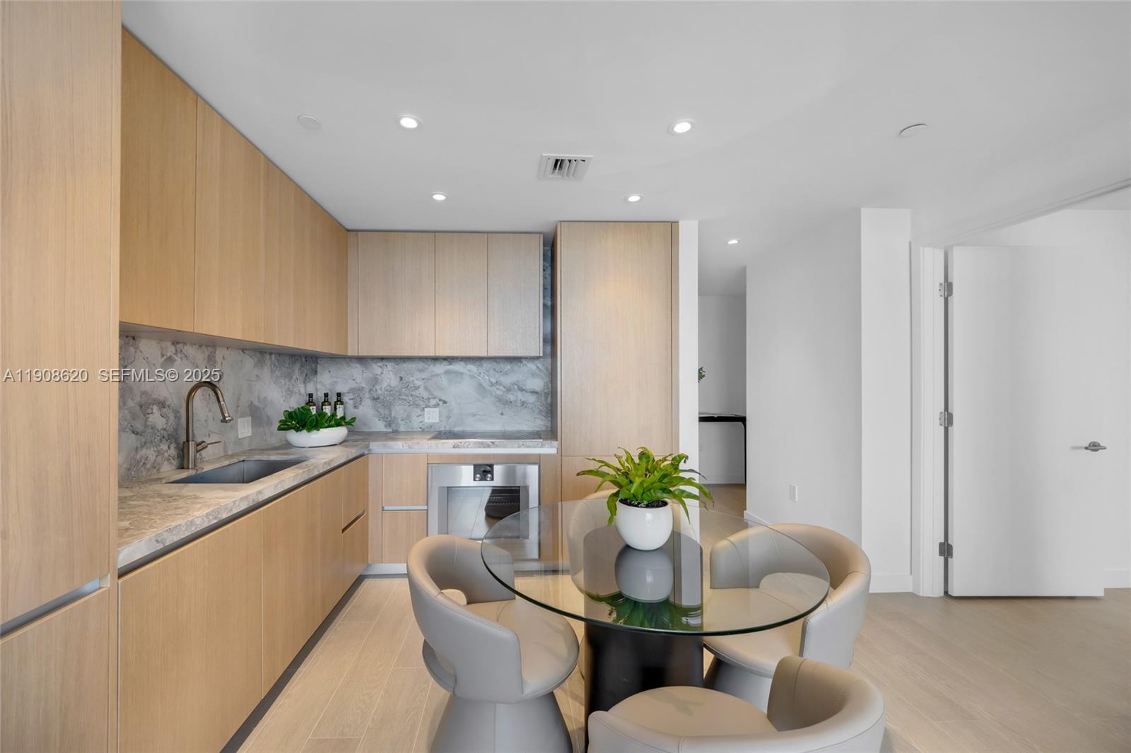 500 Alton Road, Unit 1904 Miami Beach, FL 33139 - Photo 9 of 28 a kitchen with a dining table cabinets and stainless steel appliances