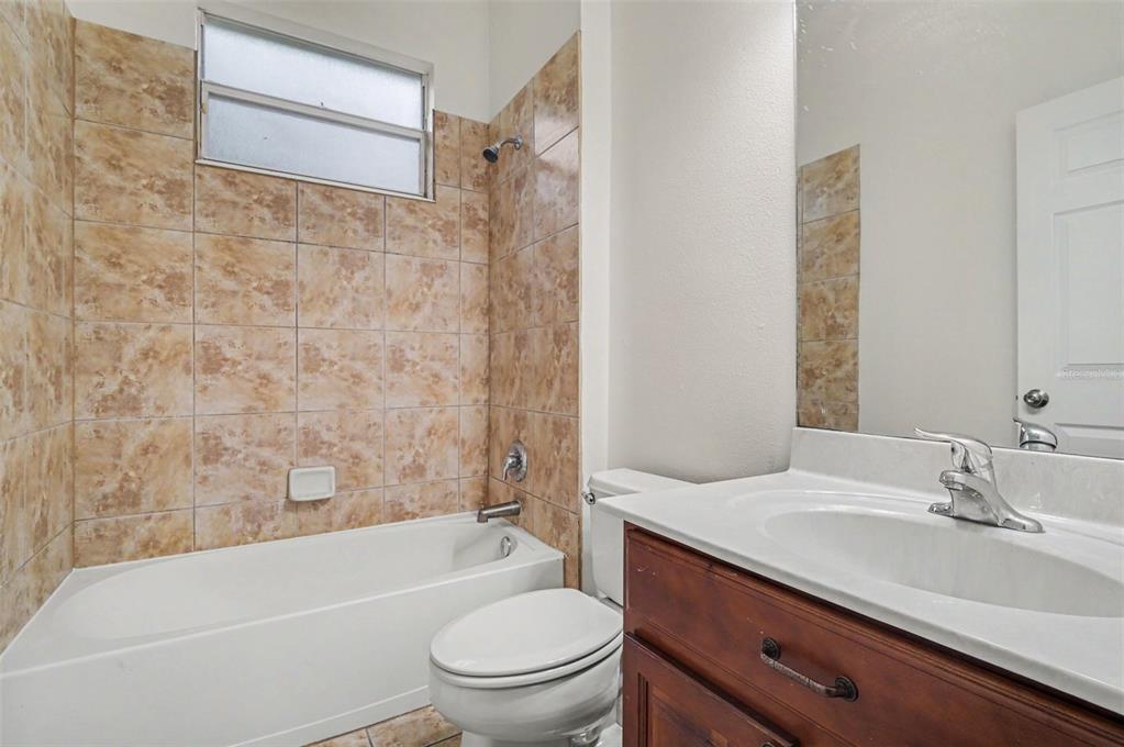 4819 Indian Deer Road Windermere, FL 34786 - Photo 27 of 30 a bathroom with a granite countertop toilet a sink and a bathtub