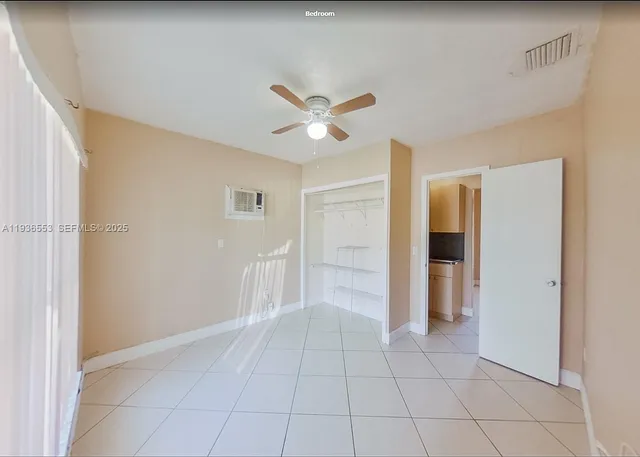 a view of an empty room with a ceiling fan