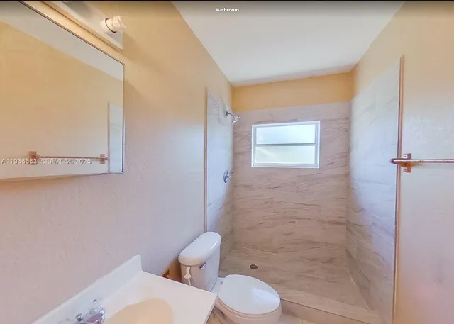 a bathroom with a toilet a sink and shower