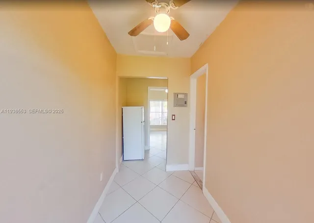 a view of a hallway with a chandelier fan and wooden floor