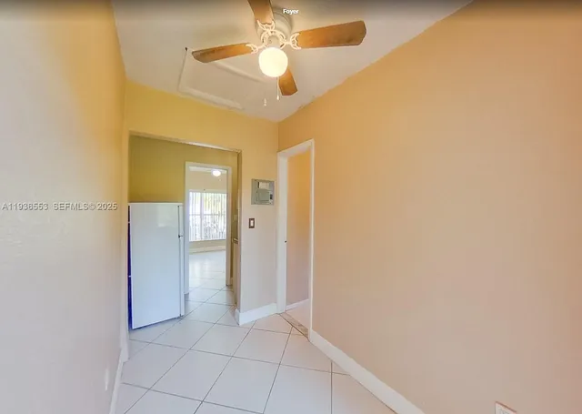 a view of an empty room and chandelier fan