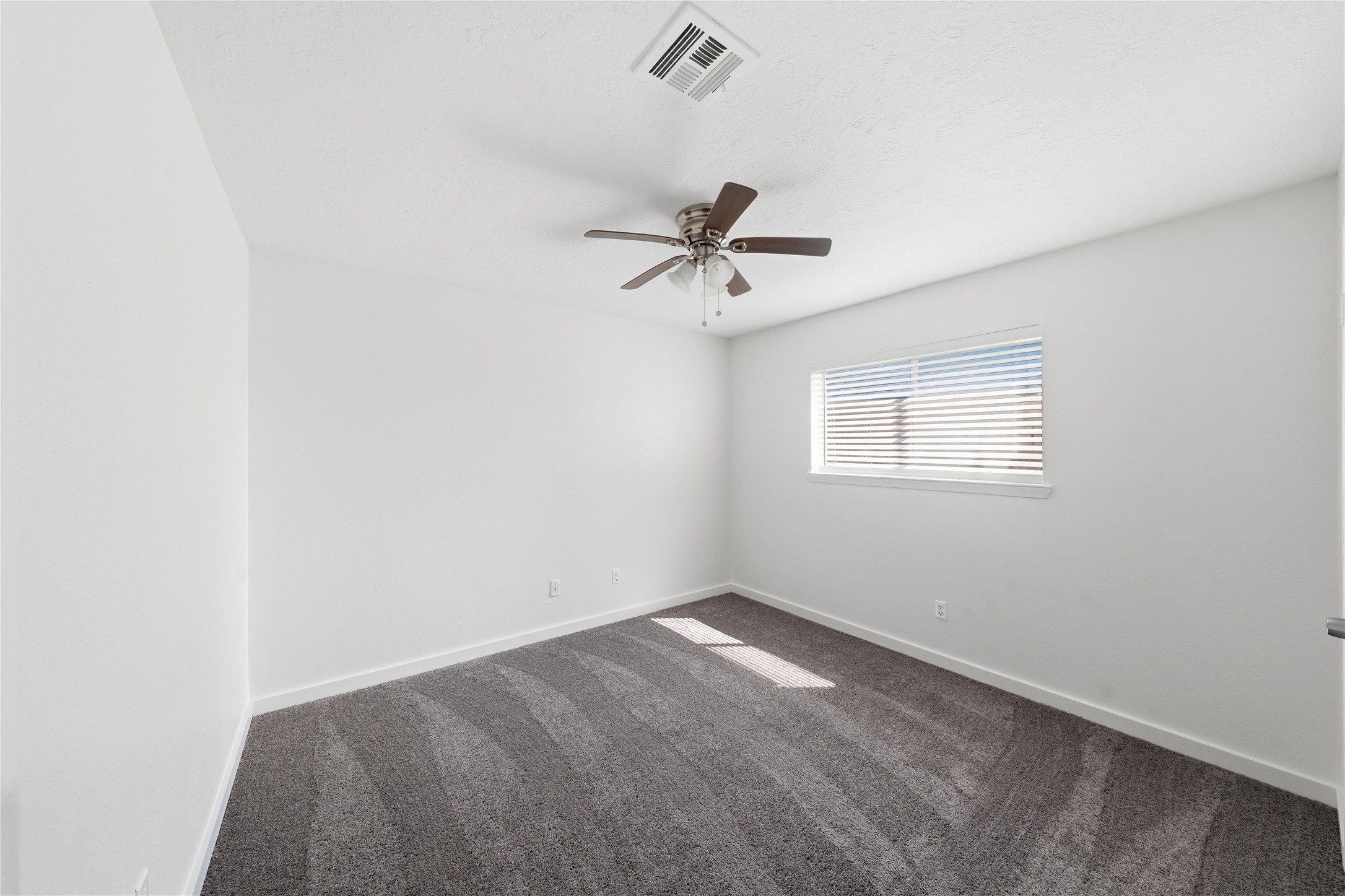 2303 Keyhole Lane Houston, TX 77084 - Photo 20 of 28 an empty room with a window and a fan