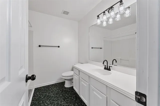 a bathroom with a sink a toilet a mirror and shower