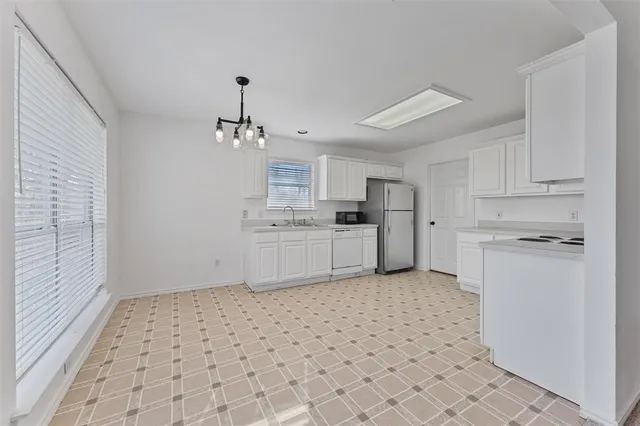 a kitchen with a sink a stove a refrigerator and cabinets