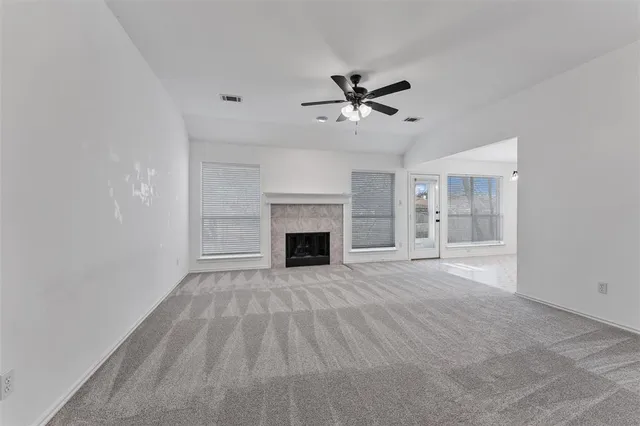 a view of empty room with a fireplace and ceiling fan