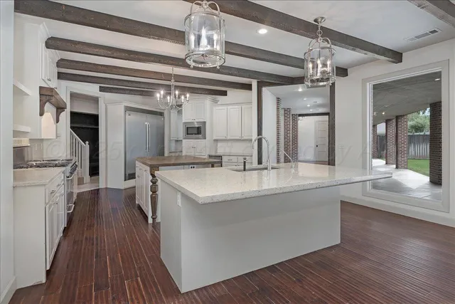 a kitchen with stainless steel appliances granite countertop a sink and wooden floor
