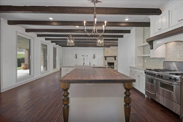 a view of an empty room with wooden floor fireplace and a window
