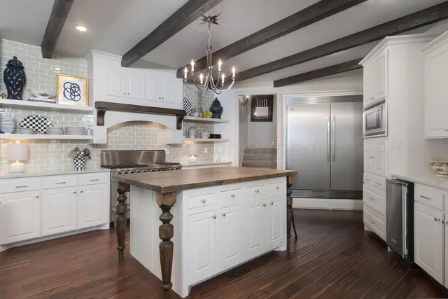 a view of an empty room with wooden floor and a fireplace