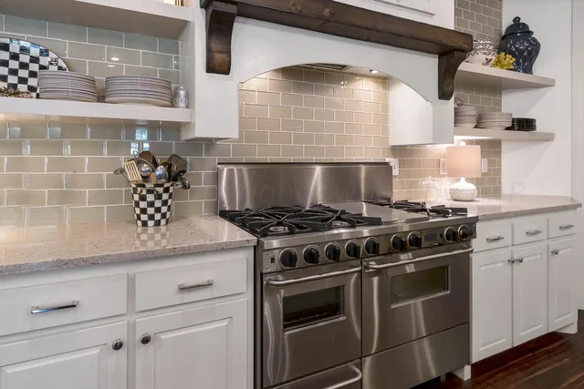 a kitchen with stainless steel appliances a refrigerator and a fireplace