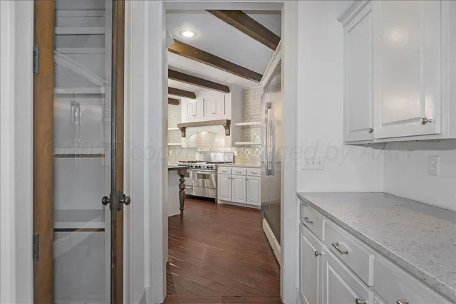 a bathroom with a granite countertop double vanity sink and mirror