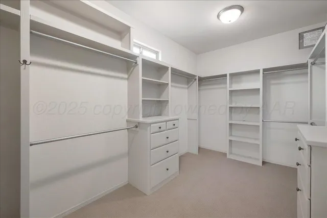a view of an empty room with a chandelier fan