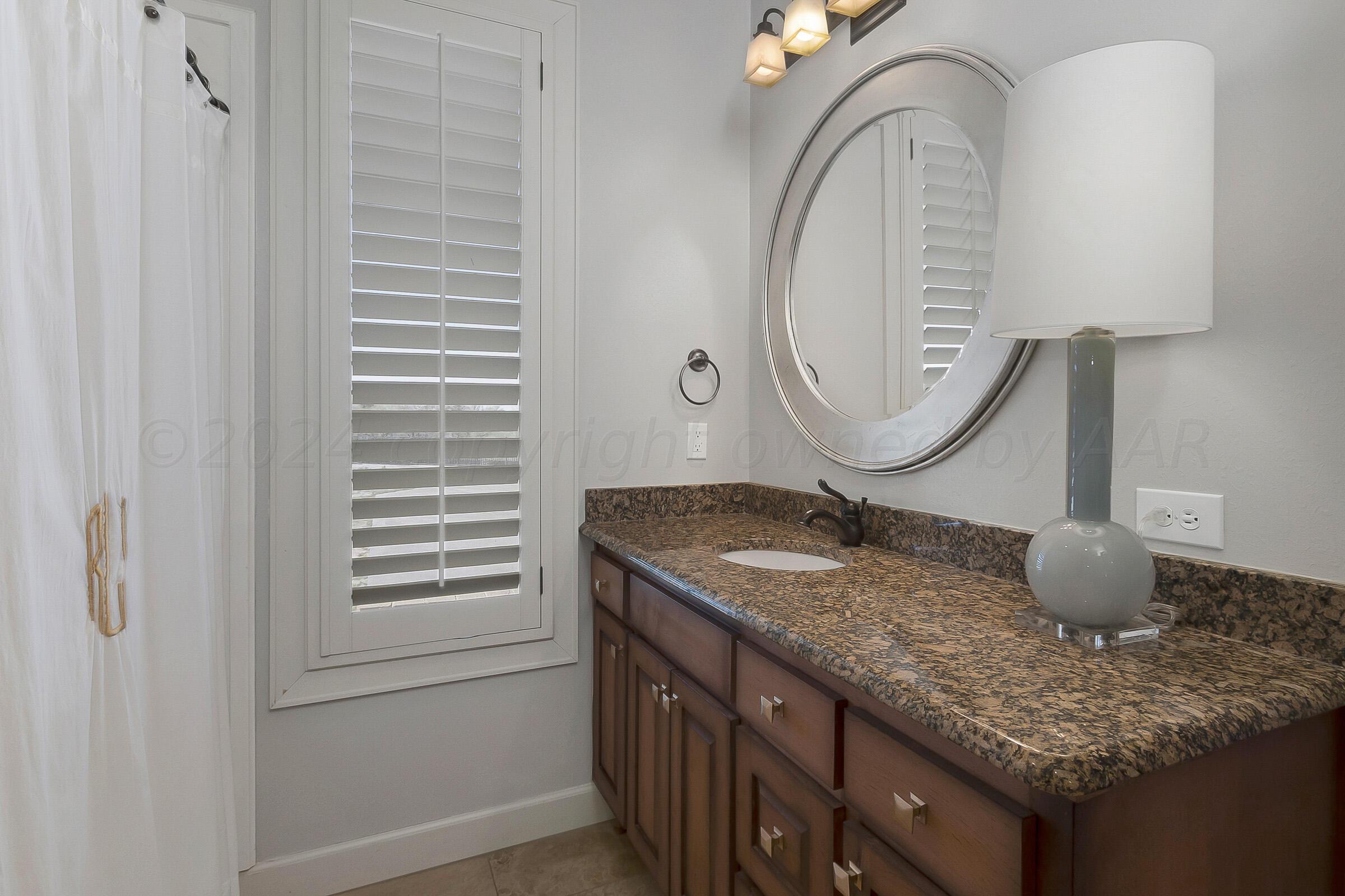 6107 Blue Sage Circle Amarillo, TX 79124 - Photo 48 of 79 a bathroom with a granite countertop sink and a mirror