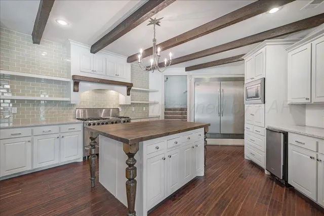 a kitchen with stainless steel appliances granite countertop a kitchen island a stove and a wooden floors