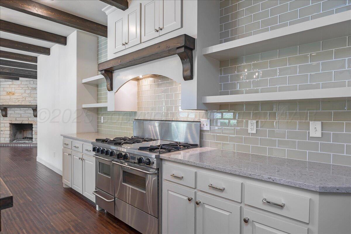 6107 Blue Sage Circle Amarillo, TX 79124 - Photo 8 of 79 a kitchen with granite countertop a stove a sink dishwasher and white cabinets with wooden floor