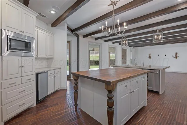 a kitchen with stainless steel appliances kitchen island granite countertop a stove a sink and a microwave