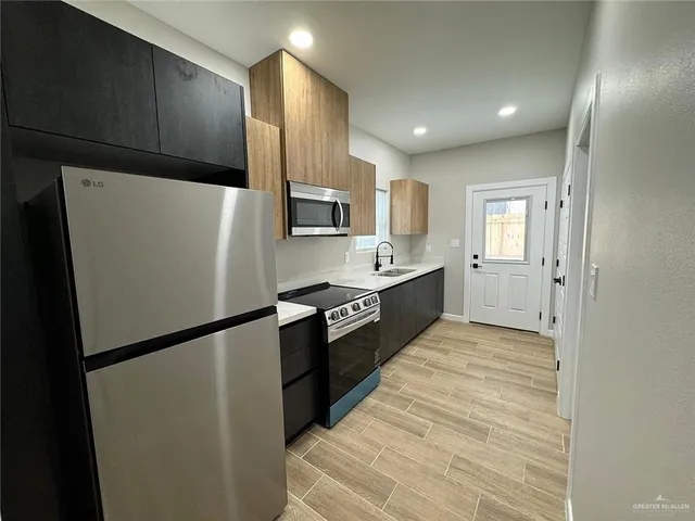 a large kitchen with a refrigerator and a sink