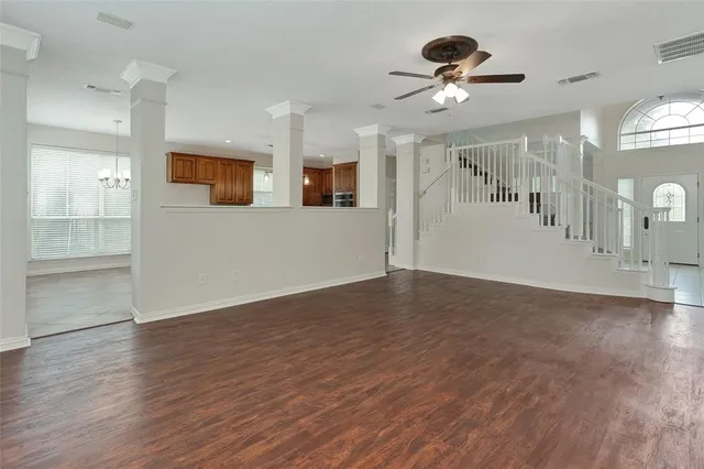 a view of a big room with wooden floor and a ceiling fan