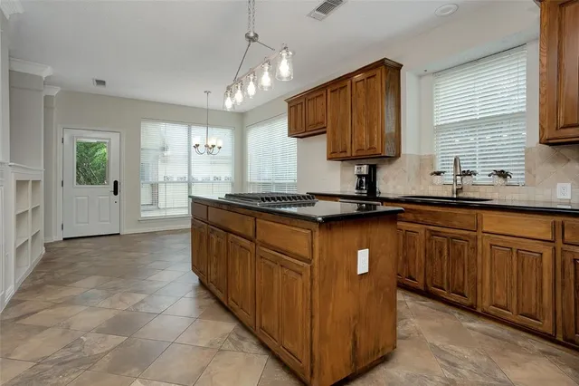 a kitchen with granite countertop a sink stainless steel appliances and cabinets