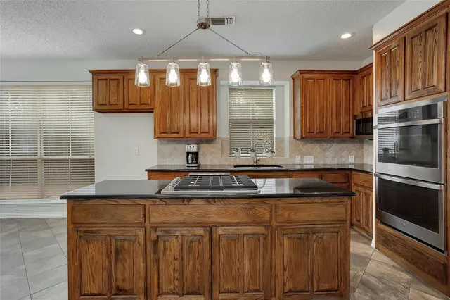 a kitchen with stainless steel appliances granite countertop a sink stove and microwave