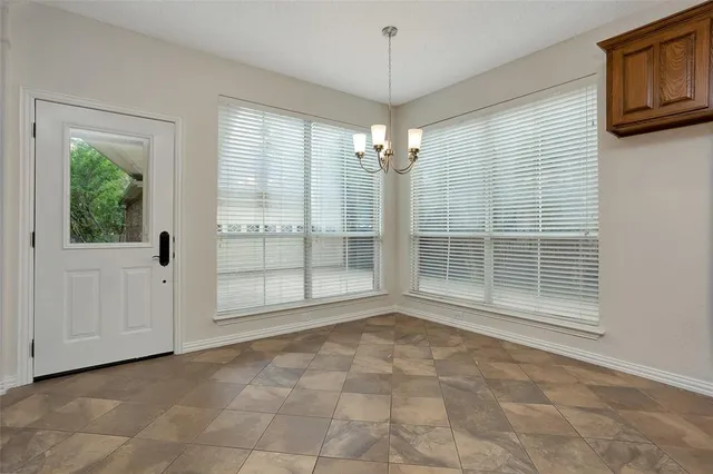 a view of a livingroom with a chandelier curtains and large windows