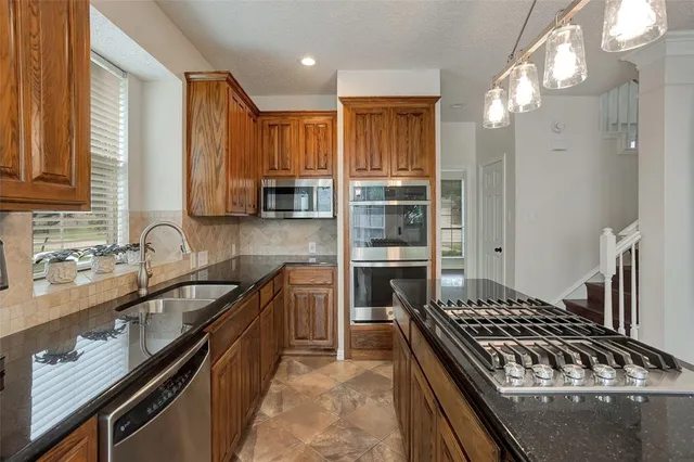 a kitchen with granite countertop a sink stove and cabinets