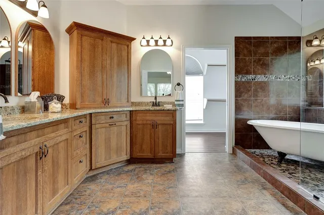 a spacious bathroom with a double vanity sink a mirror and a shower