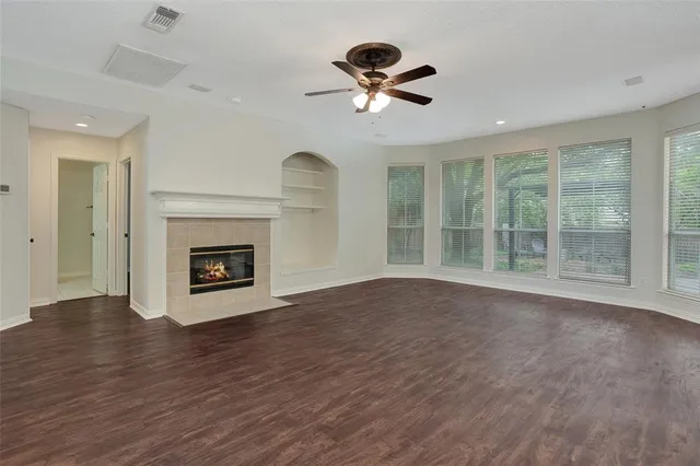 a view of empty room with wooden floor and fireplace