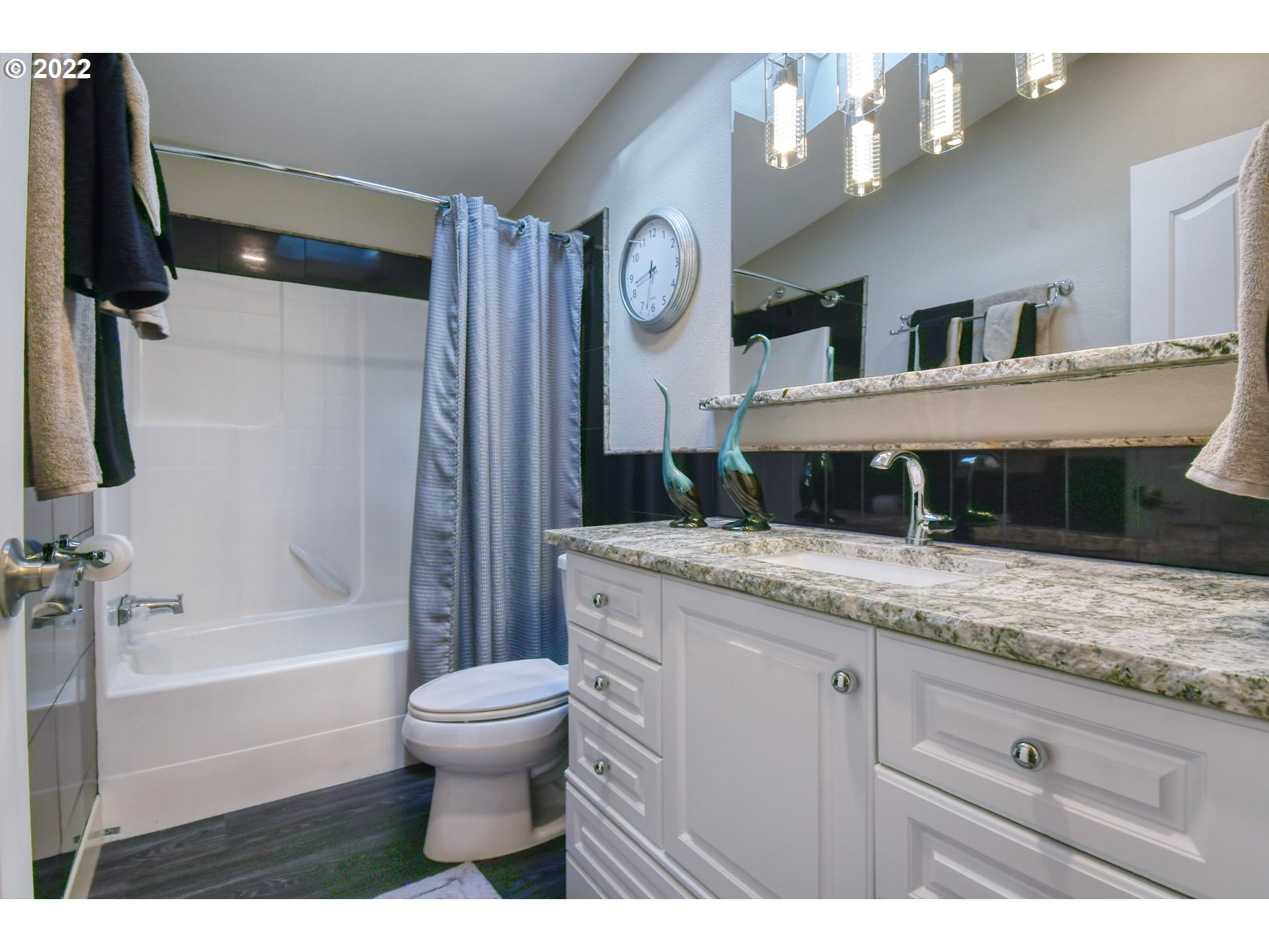 46383 Lloyd Road Pendleton, OR 97801 - Photo 20 of 32 a bathroom with a granite countertop sink a toilet and a bathtub
