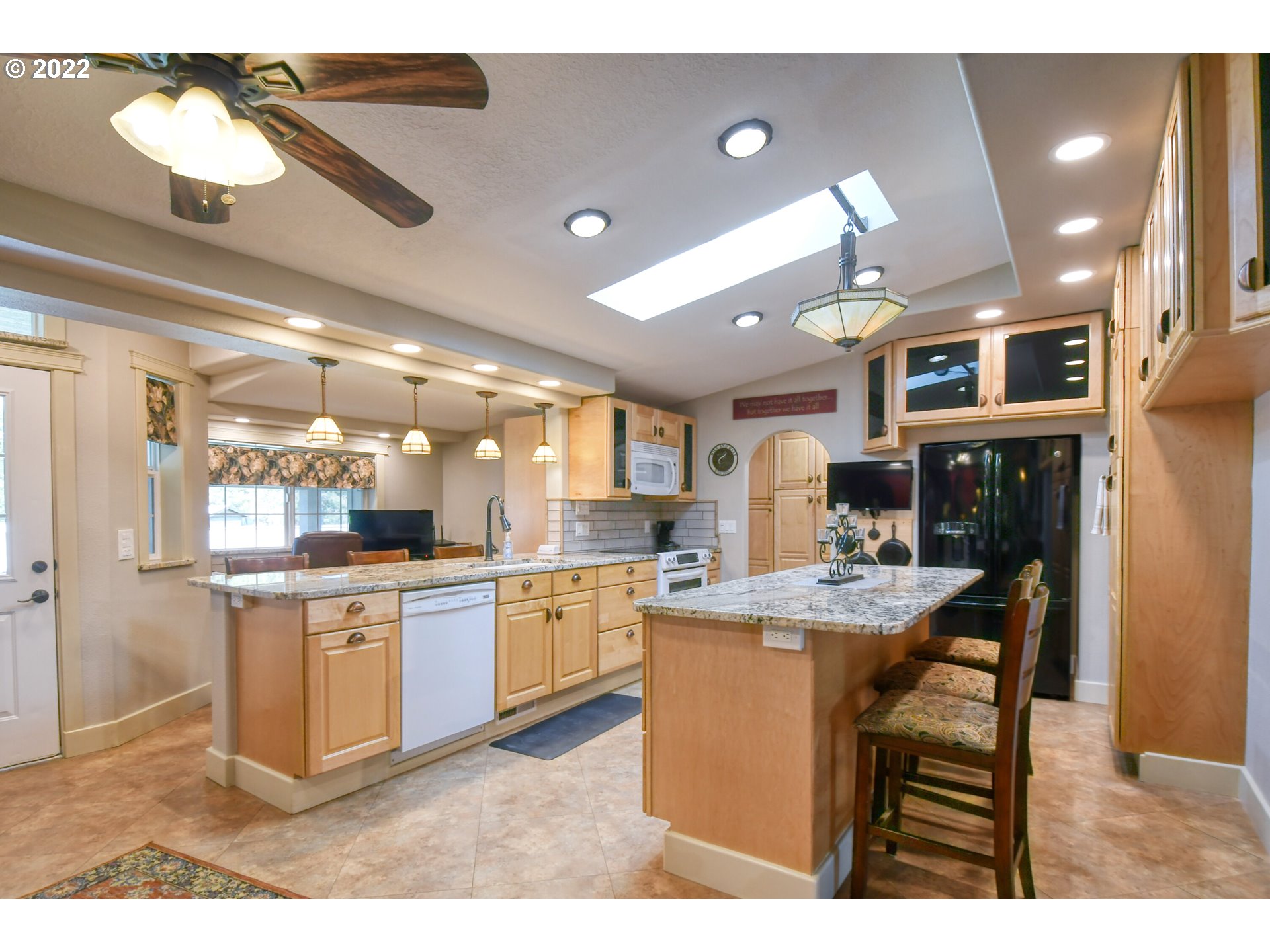 46383 Lloyd Road Pendleton, OR 97801 - Photo 8 of 32 a kitchen with stainless steel appliances kitchen island granite countertop a table chairs and a refrigerator