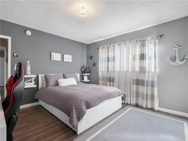 a bedroom with a bed lamp and a large window